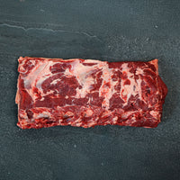 Raw ribeye steak on a dark surface